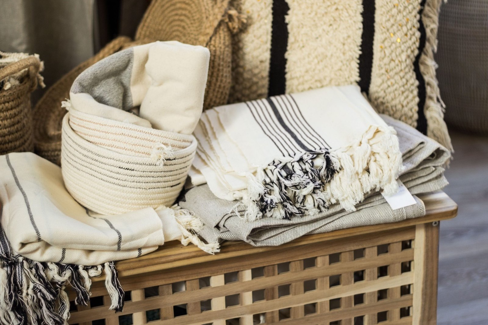 Folded linen towels and baskets on a wooden bench